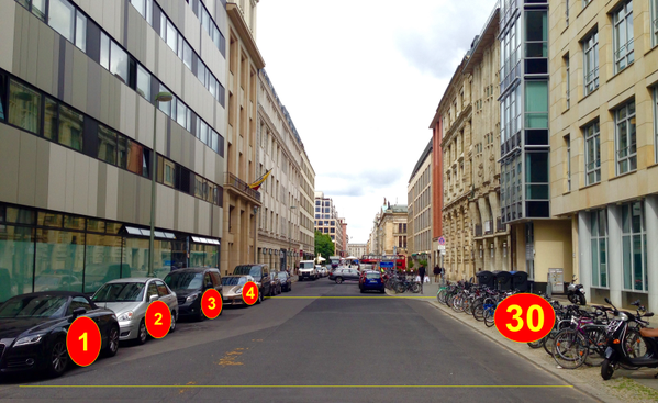 Picture of 4 parked cars taking more space than 30 parked bikes