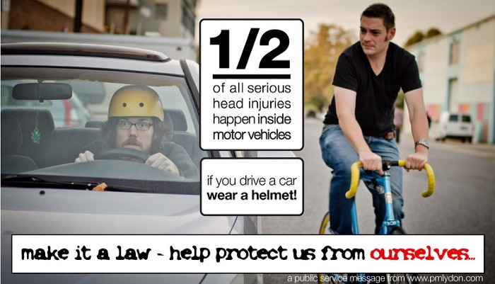 Image of a helmet-less cyclist riding next to a helmet-wearing motorist, with caption: "½ of all serious injuries happen inside motor vehicles – if you drive a car, wear a helmet!"