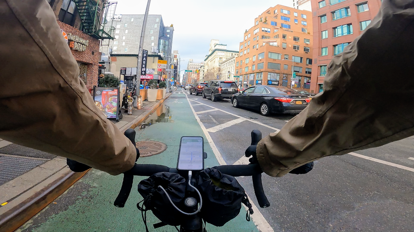 Biking on 6th Ave with battery in feedbag charging phone mounted on handlebars