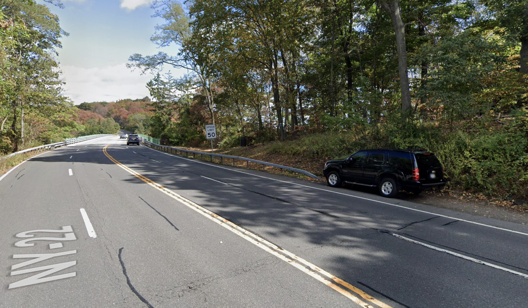 Screenshot of Street View showing the 4-lane, 50mph approach to a bridge on NY-22, a 50mph speed limit, and an SUV parked in the last few feet of shoulder before a bridge railing goes right up to the edge of the lane