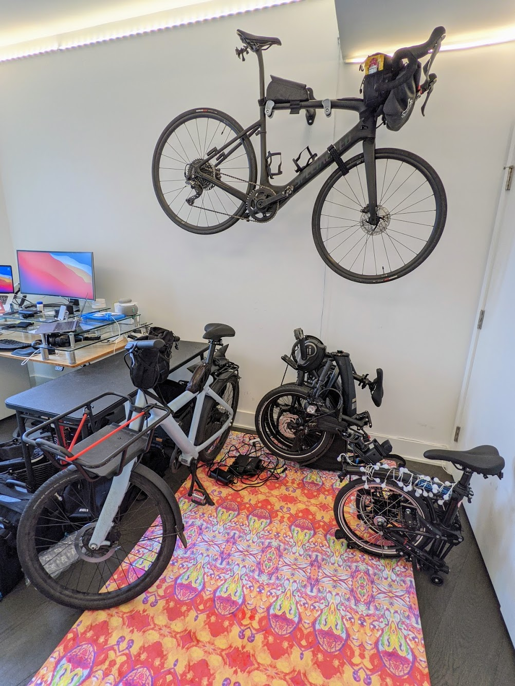 4 ebikes in my office: electric roadbike (Creo) on the wall, Brompton and Tern folded in a corner, and VanMoof X3 next to them