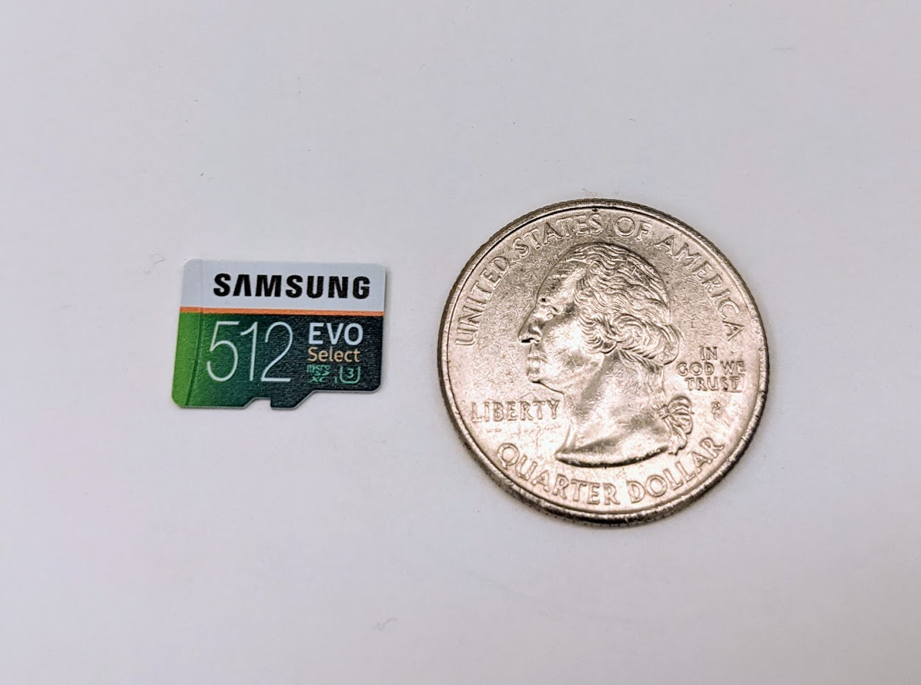 Side-by-side of a 512GB micro-SIM card and a quarter (the latter about 3x the size)