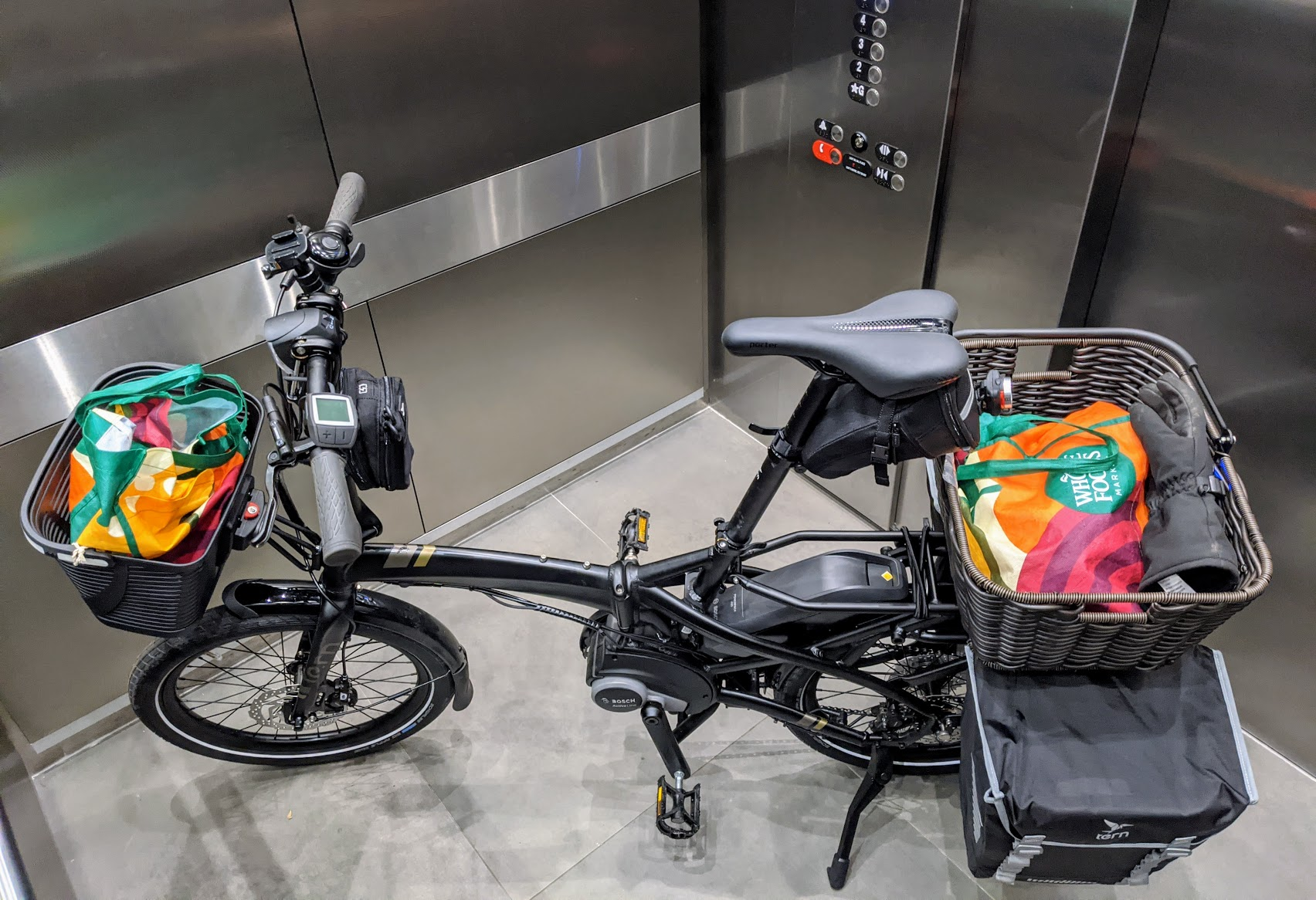 Q9 in elevator with shopping bags and panniers