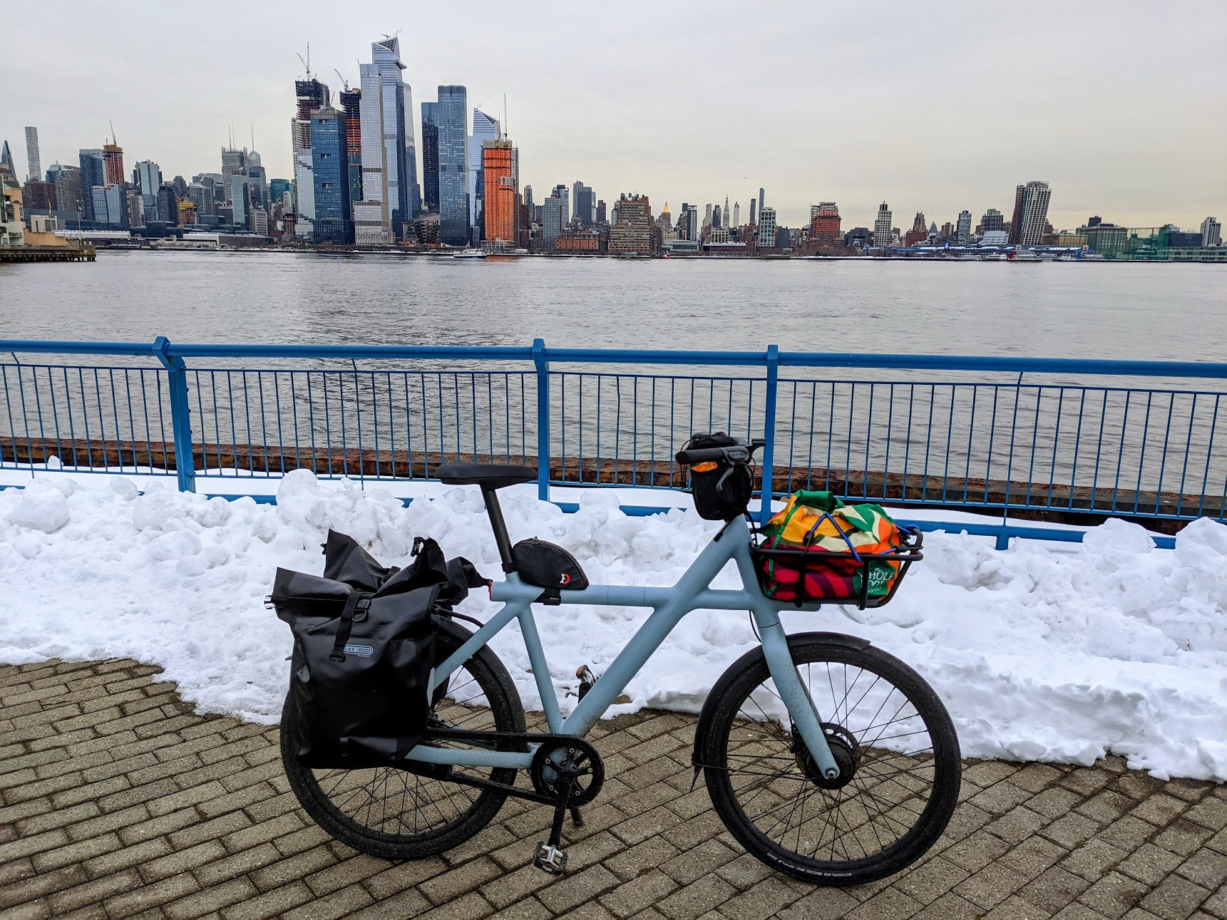 VanMoof X3 with two panniers, small tube bags, and tote bag in front rack