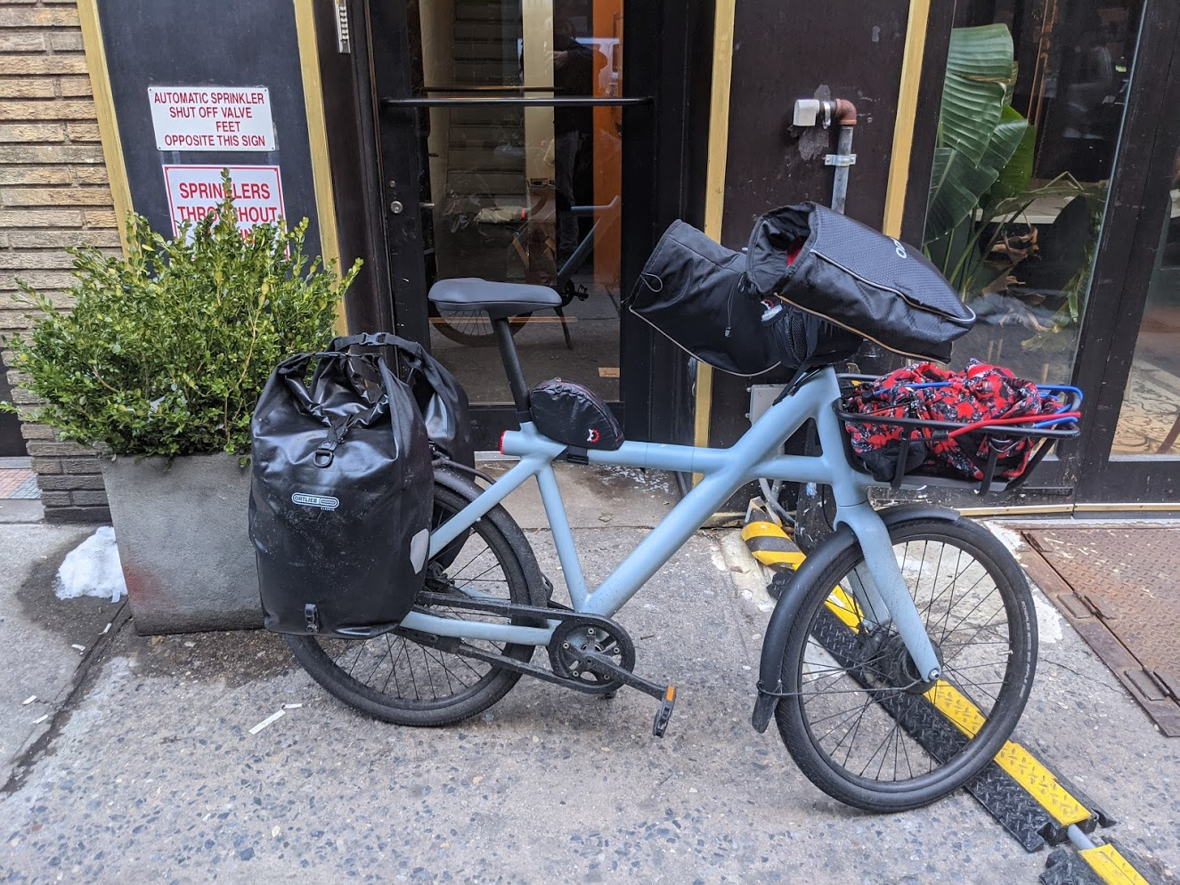 VanMoof X3 outside apartment building with 2 Ortlieb panniers on the back rack